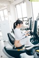 A woman sitting on a stationary bike in a gym.