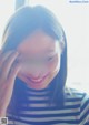 A woman in a striped shirt smiles at the camera.