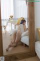 A woman sitting on a bed in front of a mirror.