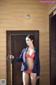 A woman in a red bikini standing in front of a door.