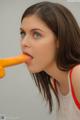 A woman with a carrot in her mouth.