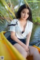 A woman sitting in a yellow canoe on a lake.