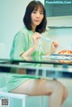 A woman sitting at a table with a plate of food.