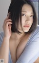 A woman in a blue shirt is posing for a picture.